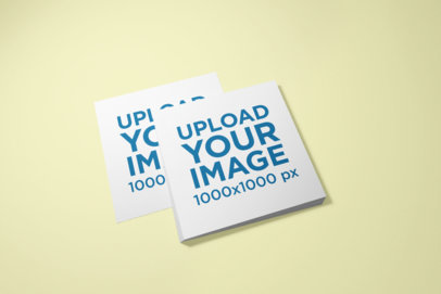 Mockup of a Pile of Square Flyers on a Surface 