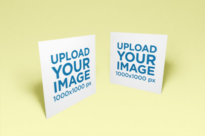 Mockup of Two Square Flyers Facing Each Other on a Flat Surface