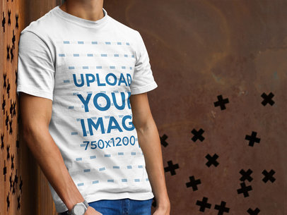 Simple T-Shirt Mockup of a Young Man Leaning Against a Wall