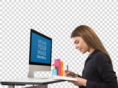 iMac Mockup of a Woman Writing in Her Agenda