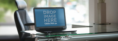 Mockup of a Laptop on a Glass Desk
