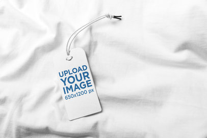 Mockup of a Brand Tag Placed over White Fabric