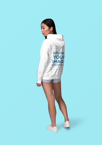 Back View Mockup of a Young Woman Wearing a Hoodie and Posing at a Studio