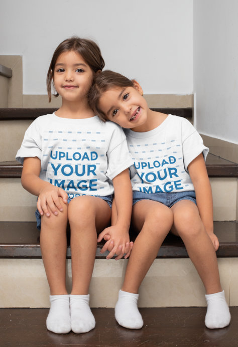 T-Shirt Mockup of Twin Girls Sitting on the Stairs 