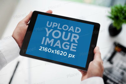 Mockup of a Businessman Holding an iPad in Landscape Position 