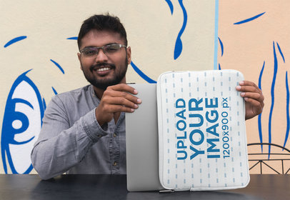 Laptop Sleeve Mockup Featuring a Smiling Man Sitting at a Dark Metal Table