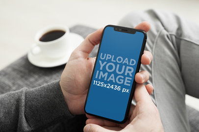 iPhone 11 Pro Mockup Featuring a Man Sitting on a Grey Fabric Couch 2150-el1