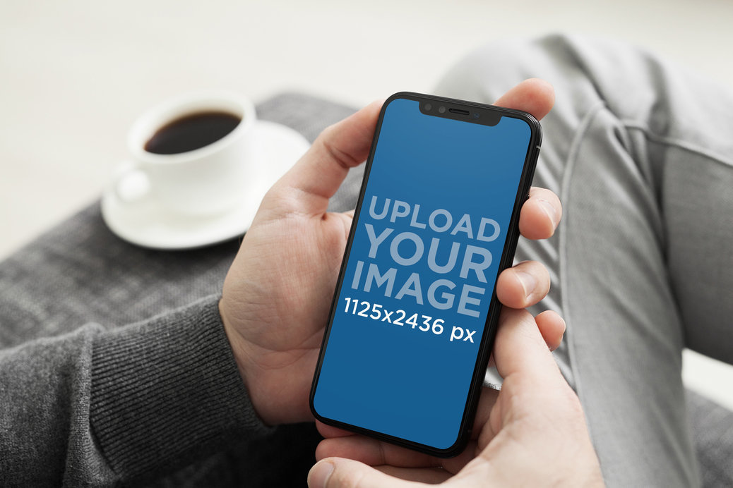 iPhone 11 Pro Mockup Featuring a Man Sitting on a Grey Fabric Couch 