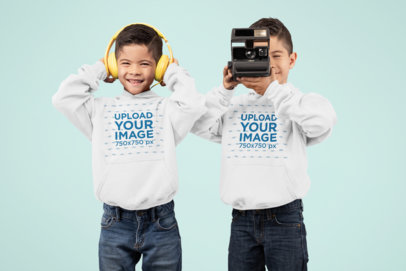 Hoodie Mockup of Twin Boys Playing with Headphones and a Camera