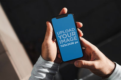 Mockup of a Man Holding an iPhone 11 Pro with Both Hands