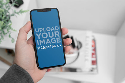 Mockup of a Man Holding an iPhone 11 Pro 