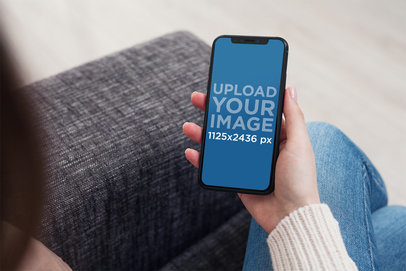 iPhone 11 Pro Mockup of a Woman Using Her Phone in a Living Room