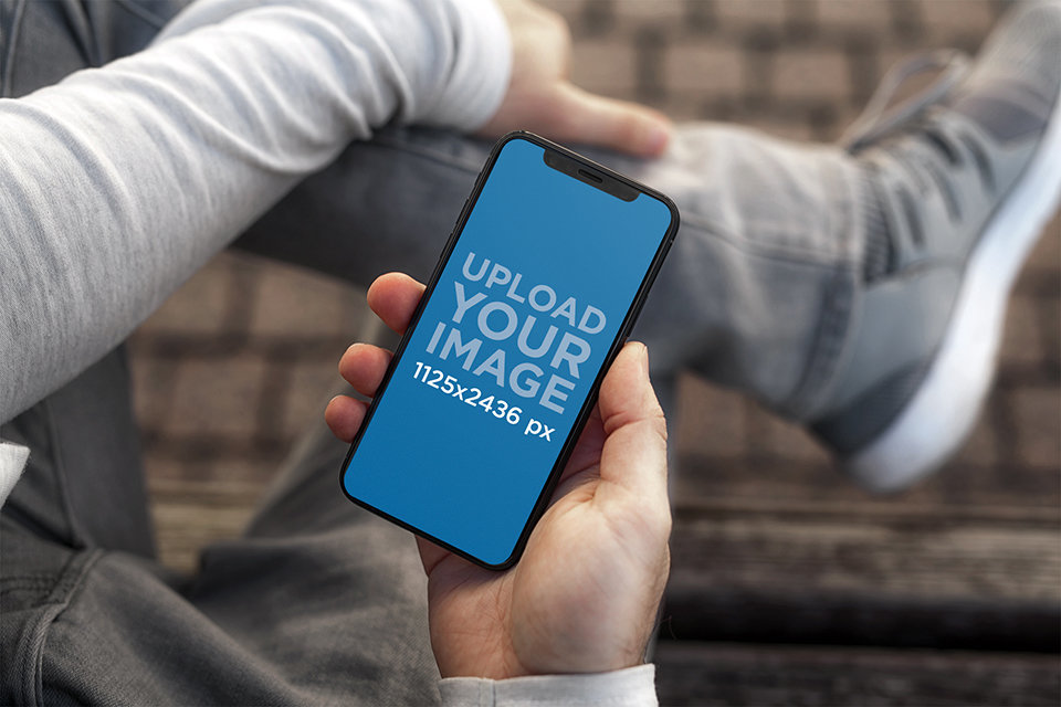 Mockup of a Young Man Holding an iPhone 11 Pro