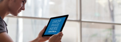 Tablet Mockup of a Young Man Using a Black iPad 