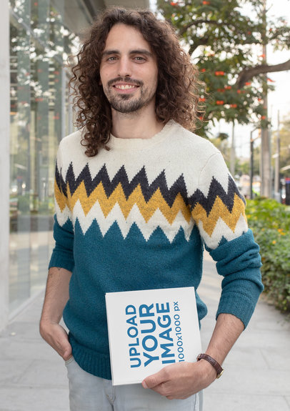 Mockup of a Long-Haired Man Holding a Squared Book