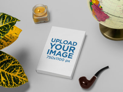 Mockup of a Paperback Book Placed Between a Pipe and a Plant 30933