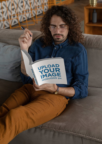 Square Book Mockup Featuring a Long-Haired Man Reading on a Couch 