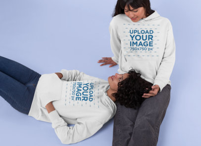 Pullover Hoodie Mockup Featuring a Couple Lying on the Floor