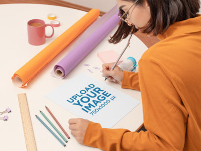 Mockup of a Woman Writing on a Sketch paper 