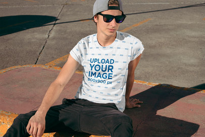 Sublimated T-Shirt Mockup of a Cool Young Man Sitting by the Street