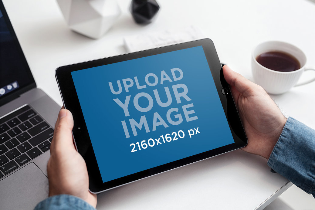 Mockup of a Man Holding an iPad While Drinking Coffee