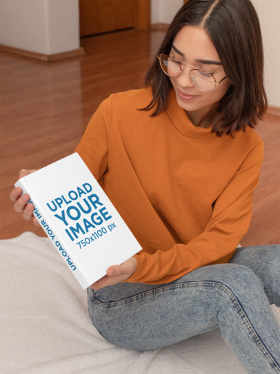 Mockup of a Woman Holding a Hardcover Book at Home 31041