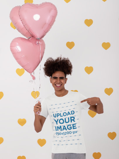 Mockup of a Man Pointing at His T-Shirt and Holding Heart-Shaped Balloons