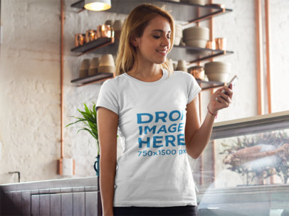 T-Shirt Mockup of a Young Woman Texting at Home