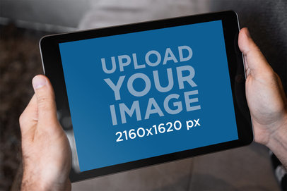 Mockup of the Hands of a Man Holding an iPad in Landscape Position