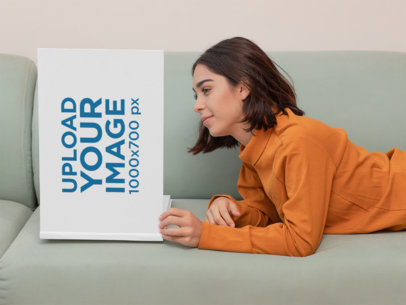 Book Mockup Featuring a Young Woman Reading on a Couch 