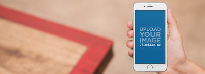 Mockup of a Person Using an iPhone 6s at Home