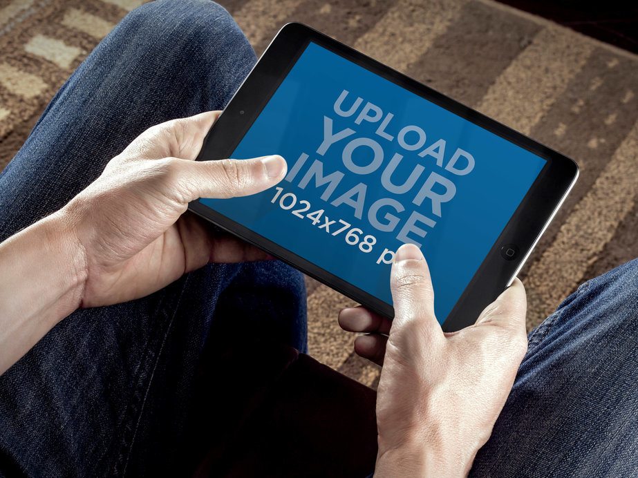 Mockup of a Man Playing on His iPad Mini 