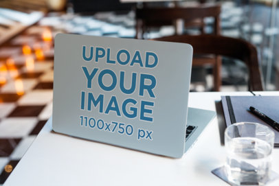 Laptop Cover Mockup with a Computer Placed Next to a Glass of Water