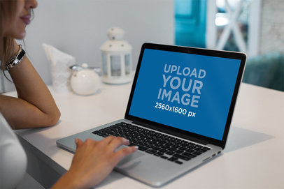 MacBook Pro Mockup Featuring a Woman Working on Her Computer at a Cafe 