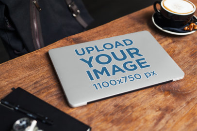 Laptop Cover Mockup of a Computer Placed on a Wooden Table Next to a Coffee