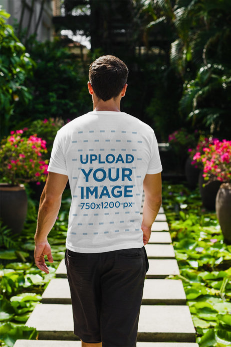 Back View T-Shirt Mockup of a Man Walking Through a Tropical Hallway 