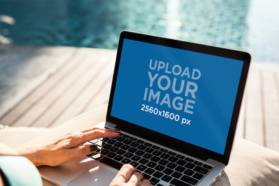 Mockup of a Woman Working on Her MacBook Pro by a Pool 