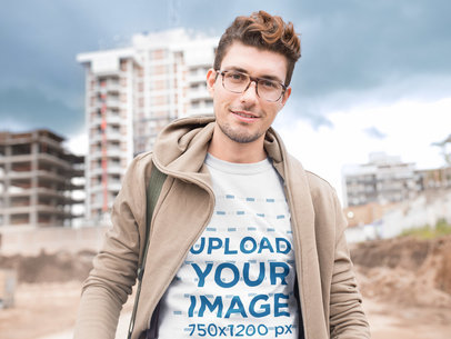 Front Tee Mockup of a Young Hipster Near an Urban Scape
