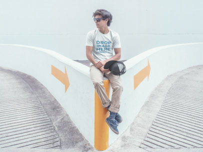 T-Shirt Mockup of a Trendy Guy Sitting in a Parking Lot
