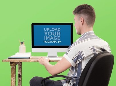 Mockup of a Man Typing on his iMac