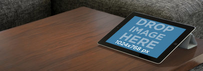 Mockup of a Black iPad on a Living Room's Table 