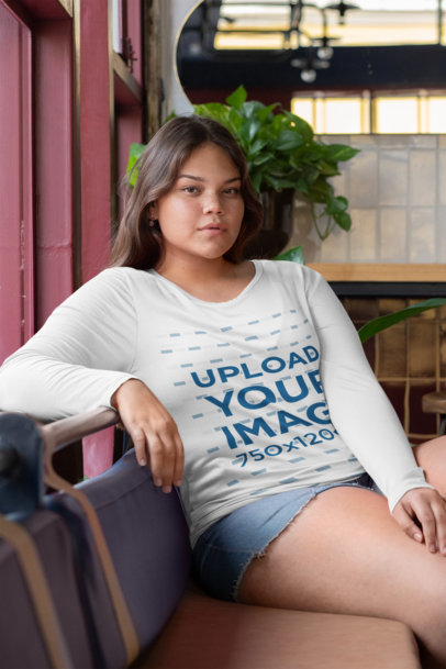 Plus Size Mockup of a Young Woman with a Long-Sleeve Tee Sitting on a Couch 