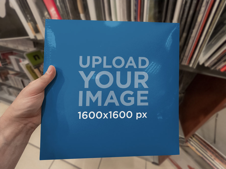 Mockup of a Man Holding a Vinyl Cover at a Music Store