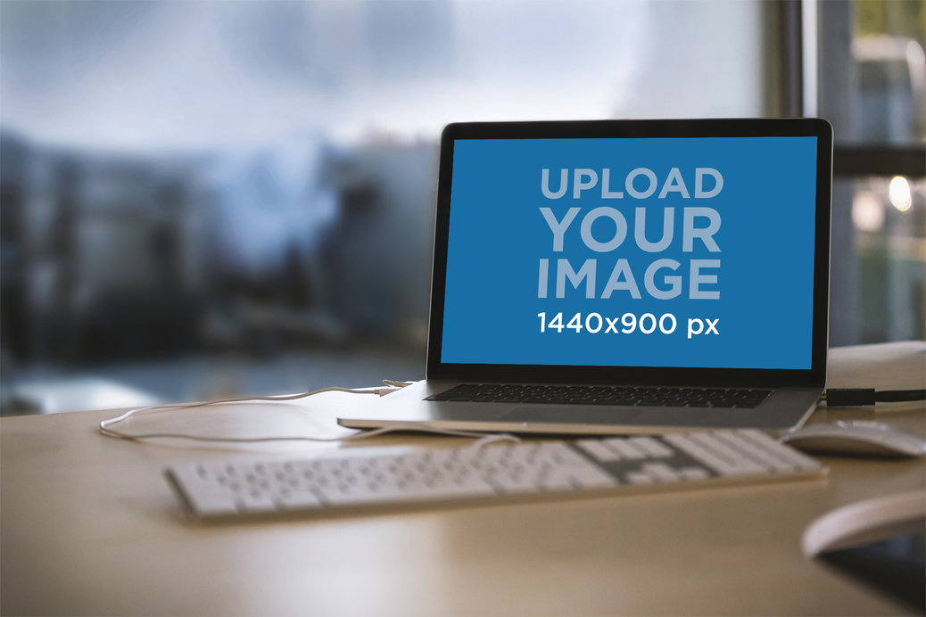 Mockup Featuring a Macbook Placed on a Desk at an Office 