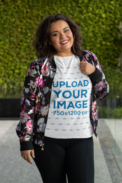 Plus Size T-Shirt Mockup Featuring a Joyful Woman Posing in Front of a Leafy Background