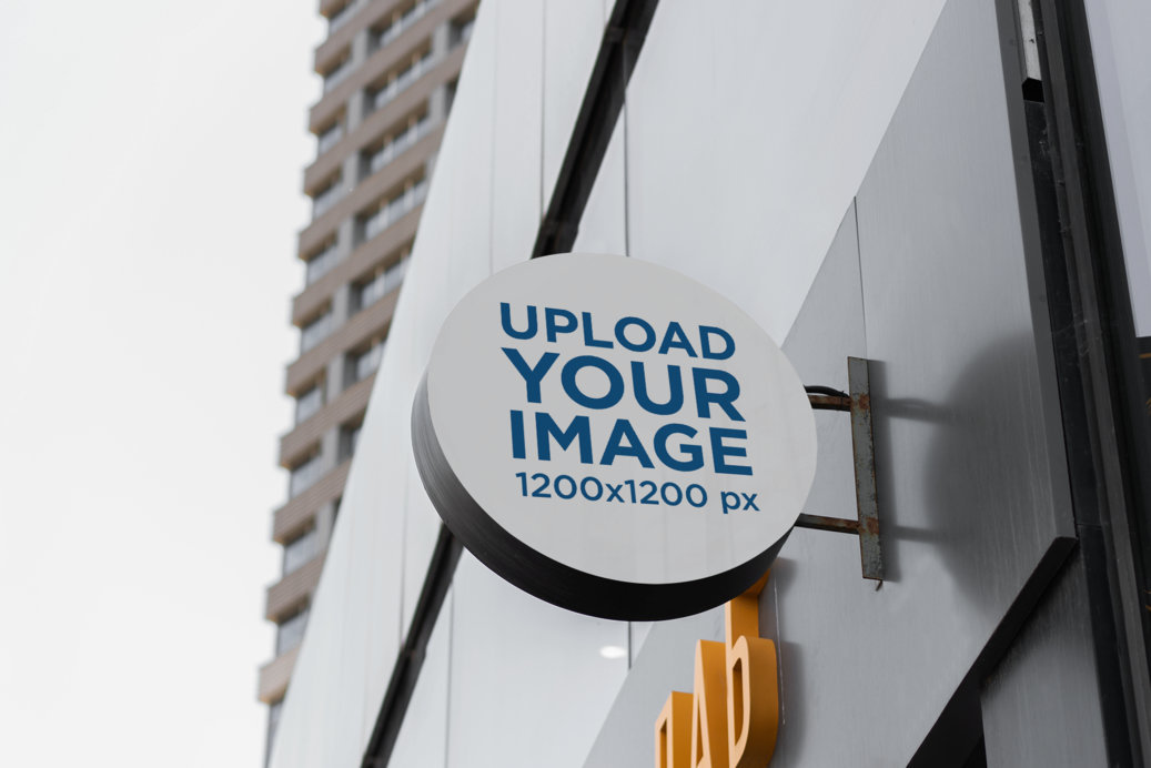 Placeit - Mockup of a Round Sign on a Dark Modern Building