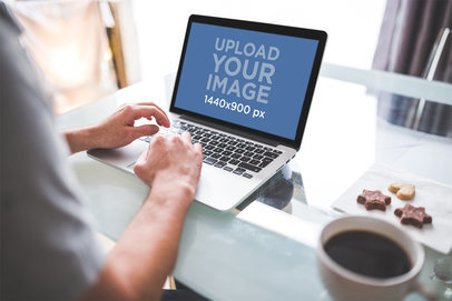 Mockup of a Man Working on a MacBook Pro at Home 