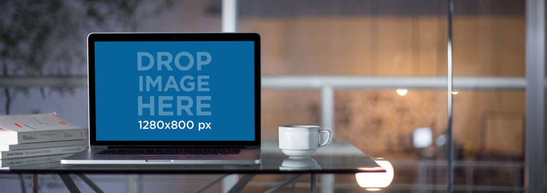 Front View of a MacBook Pro Mockup in a Glass Office