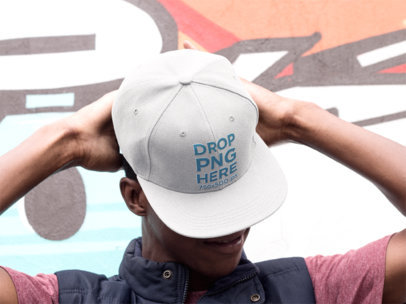 Snapback Hat Mockup of a Young Man Near a Graffiti Wall
