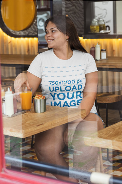 Plus Size T-Shirt Mockup Featuring a Smiling Woman at a Restaurant